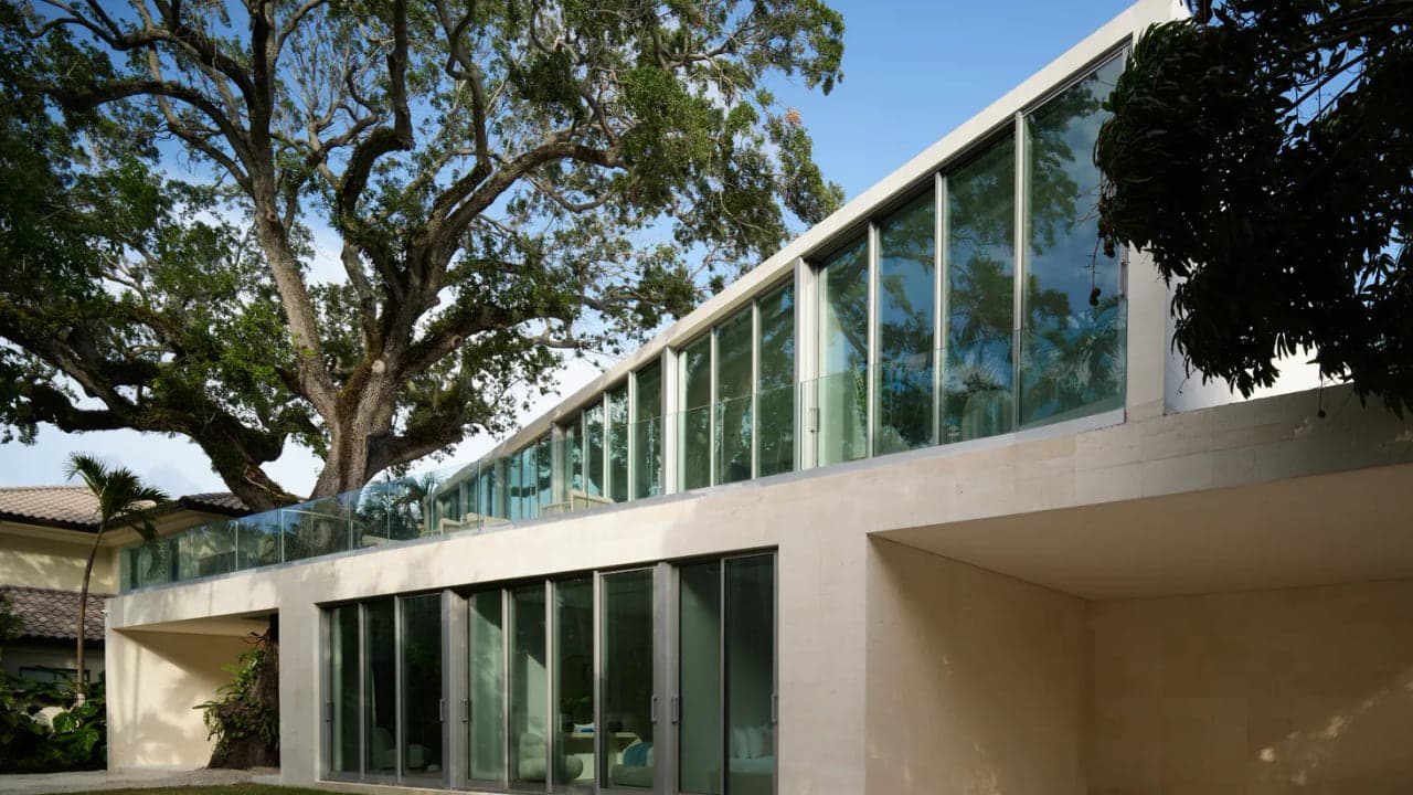 Close up of a modern Miami home's continuous glass wall with slim aluminum frames and floor to ceiling glazing, no people in frame