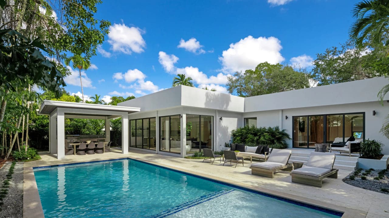 Exterior view of a modern Coconut Grove home showing the conditioned living volume against its covered porches and terraces