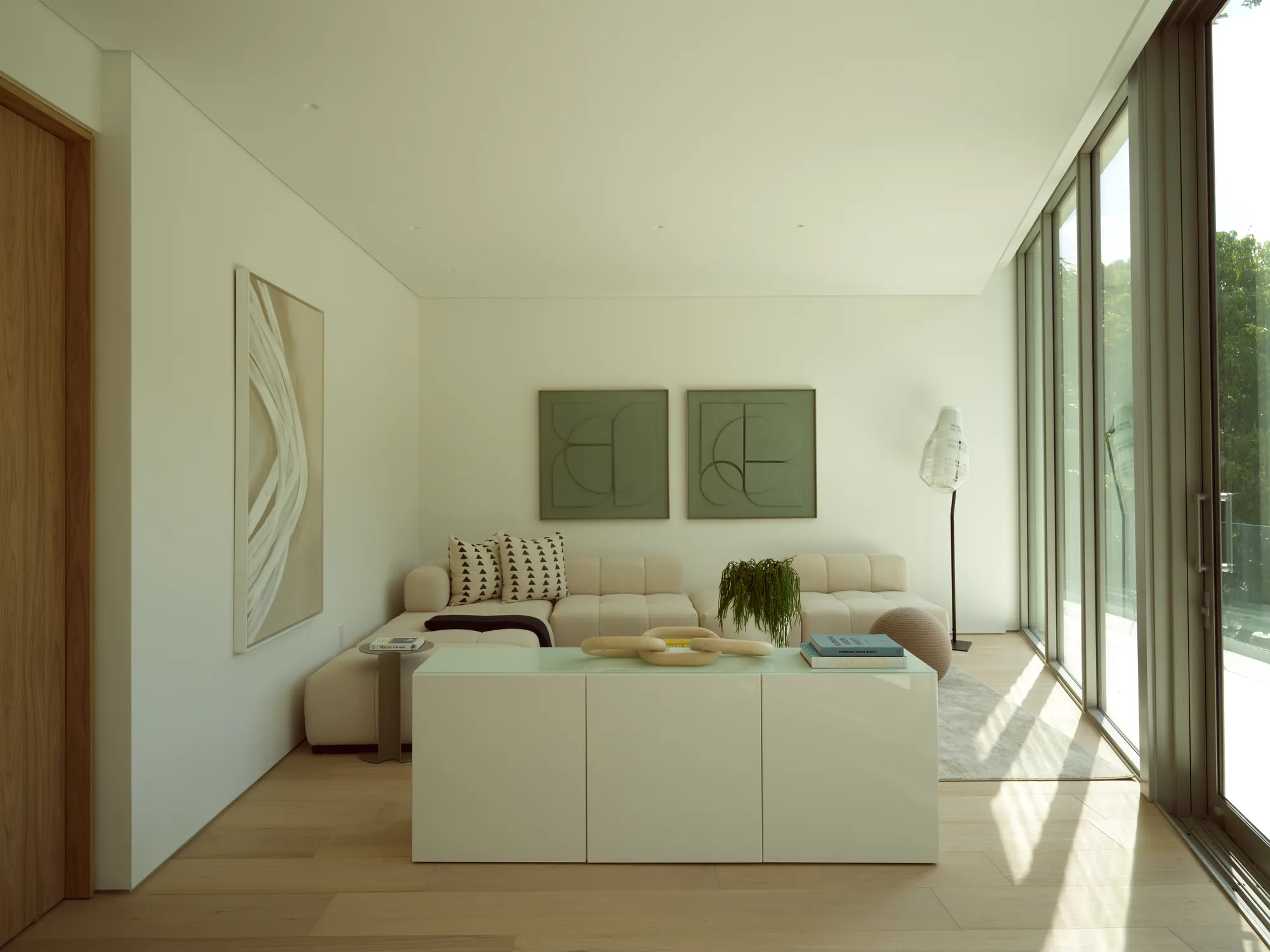Pared-back living room with natural materials and soft daylight in the Onaway residence by LUXOM
