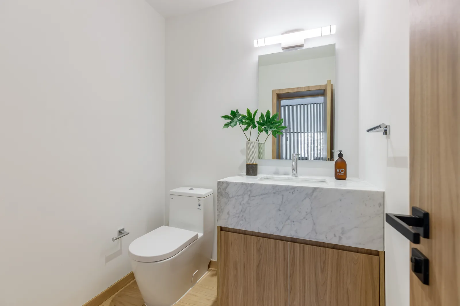 Serene spa-style wellness bath with a freestanding tub and backlit mirror in the Samana residence by LUXOM