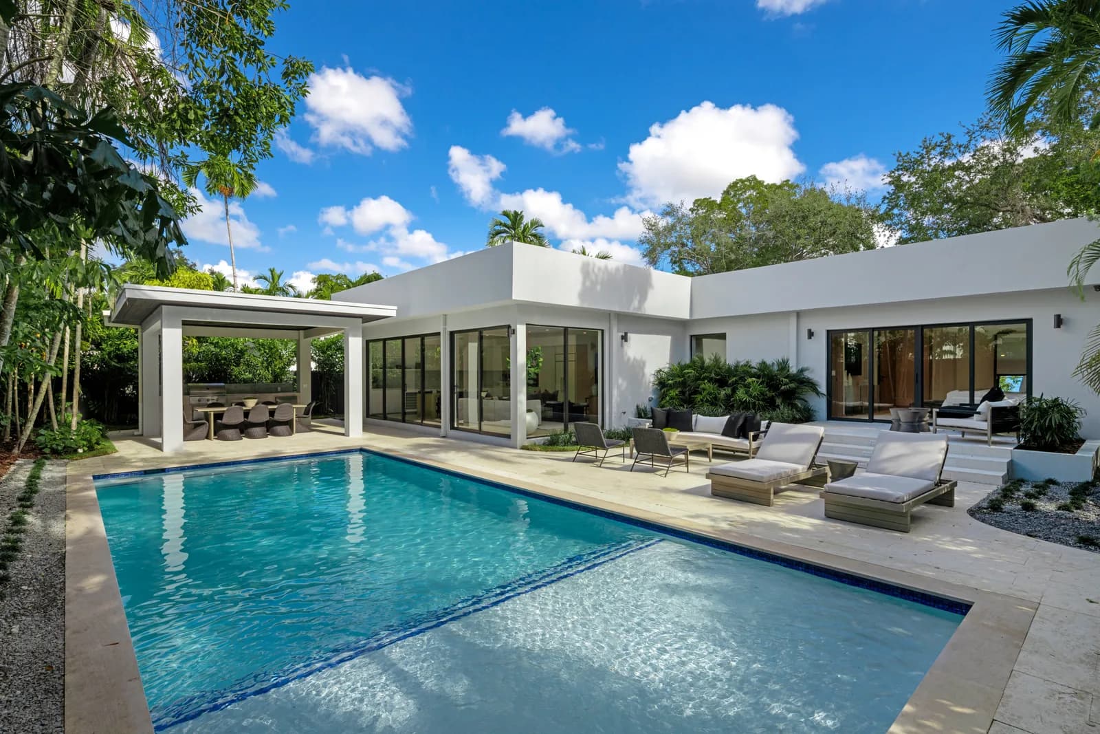 A Luxom built Miami residence: the main house and a covered outdoor pavilion set on either side of a shared pool and lawn